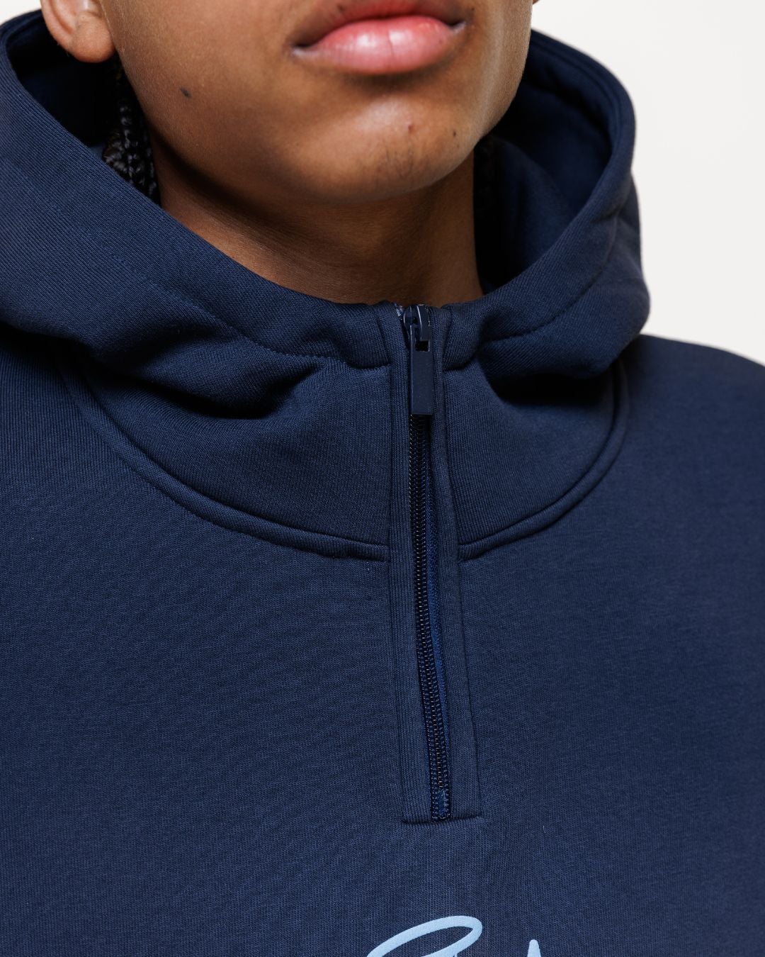 Close-up of navy hoodie neckline showing half-zip closure detail