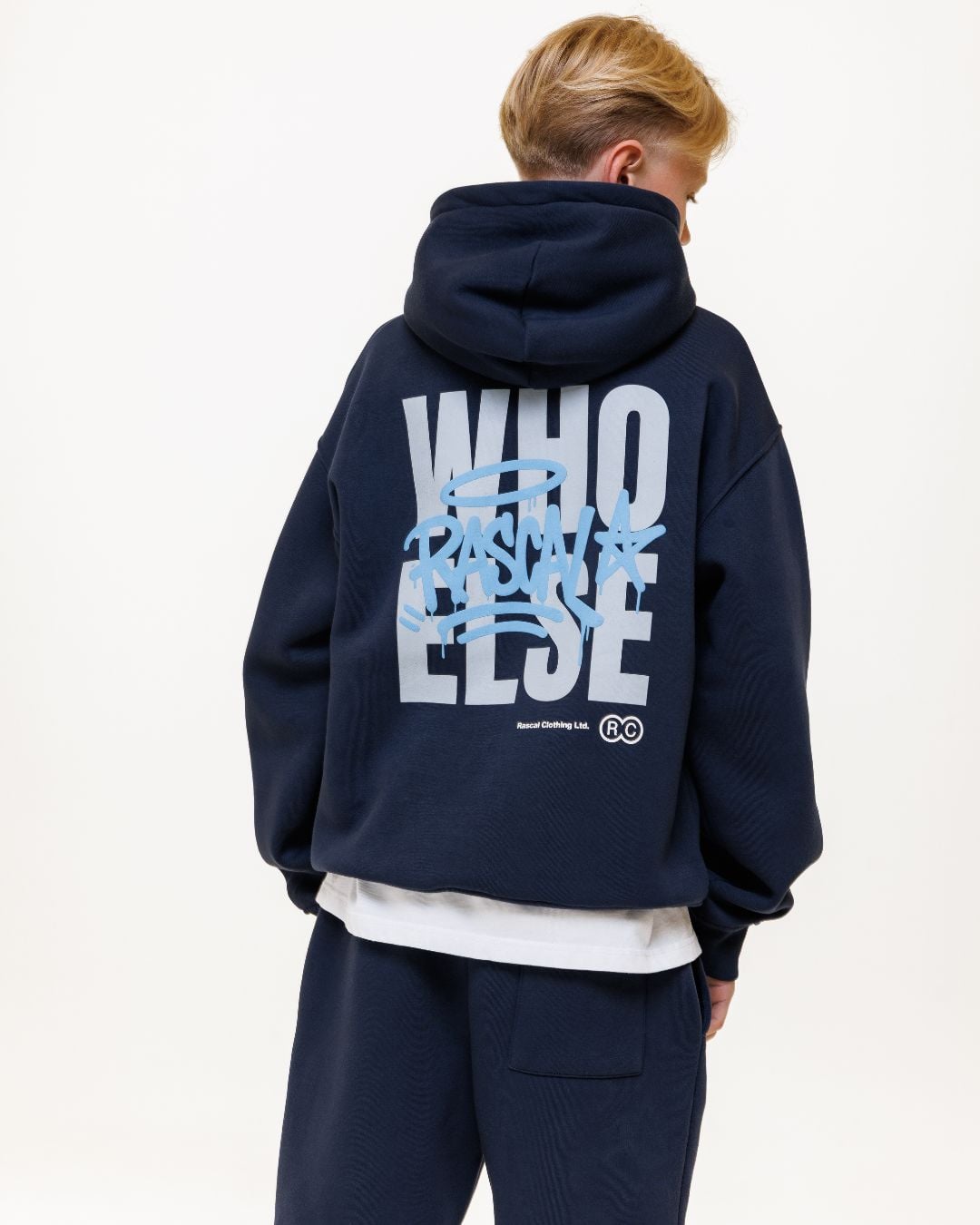 Back view of child wearing navy hoodie and cargo pants with large white and light blue graphic on back