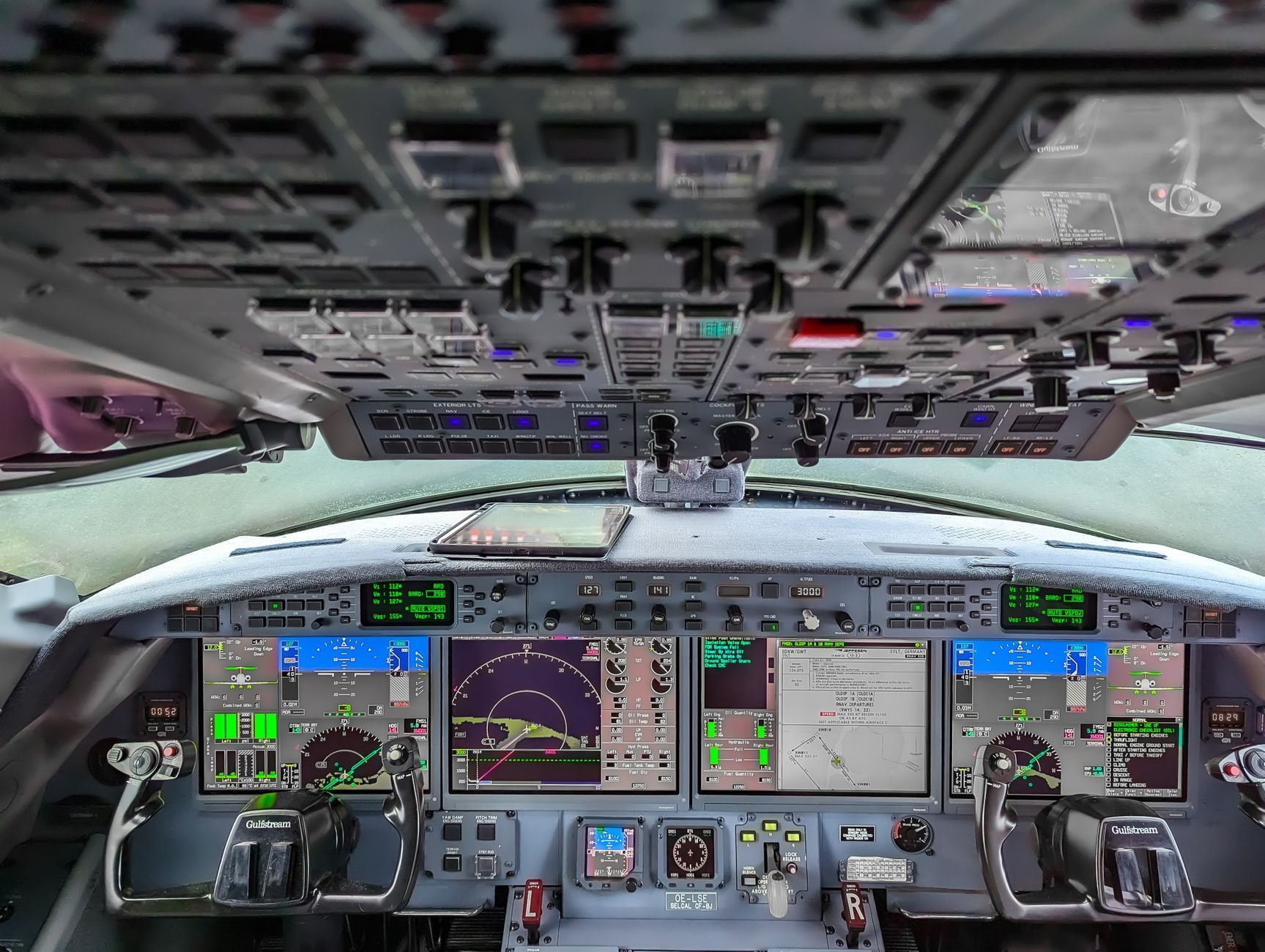 Commercial aircraft cockpit interior showing instrument panel with multiple displays, gauges, and control systems